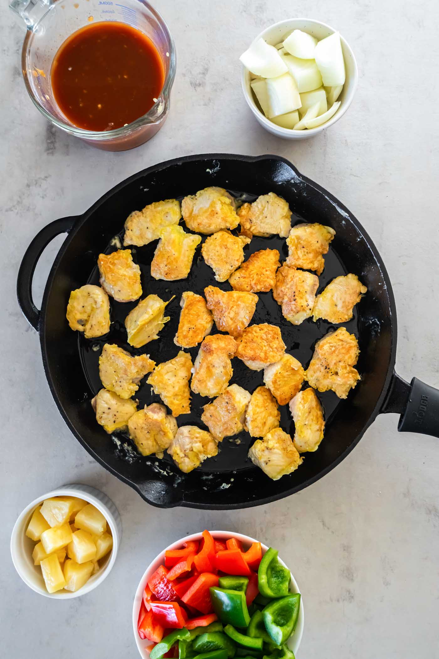Browning chicken pieces in skillet.