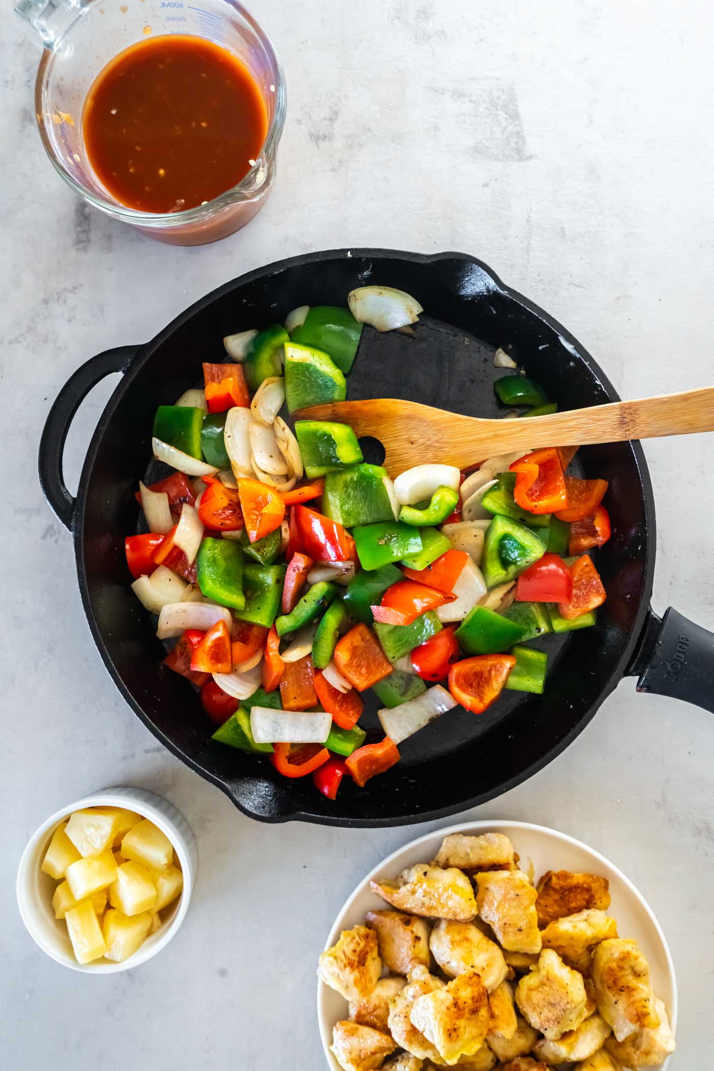 Sautéing bell peppers and onion in skillet.