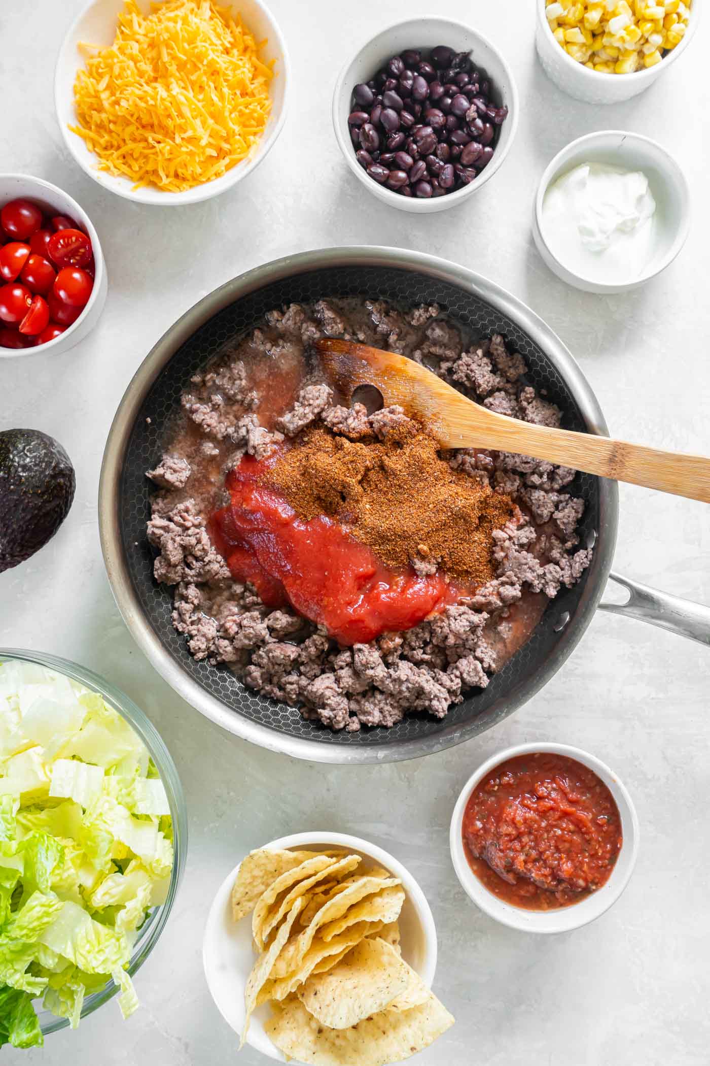 Tomato sauce, taco seasoning and water added to browned ground beef in skillet.