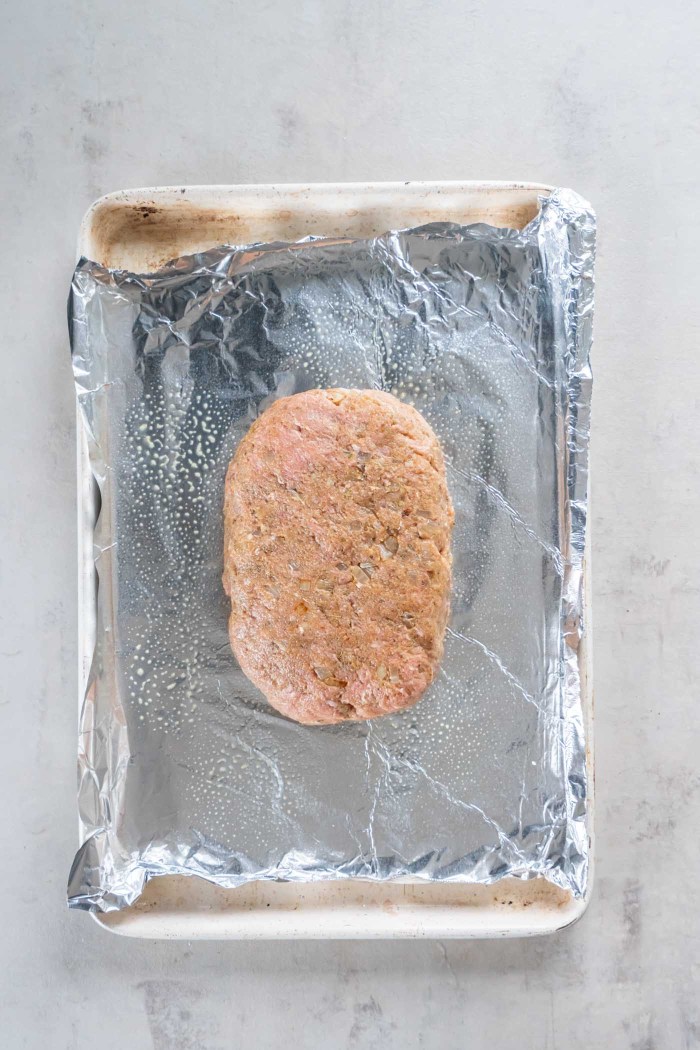 Unbaked turkey meatloaf on foil-lined baking sheet.