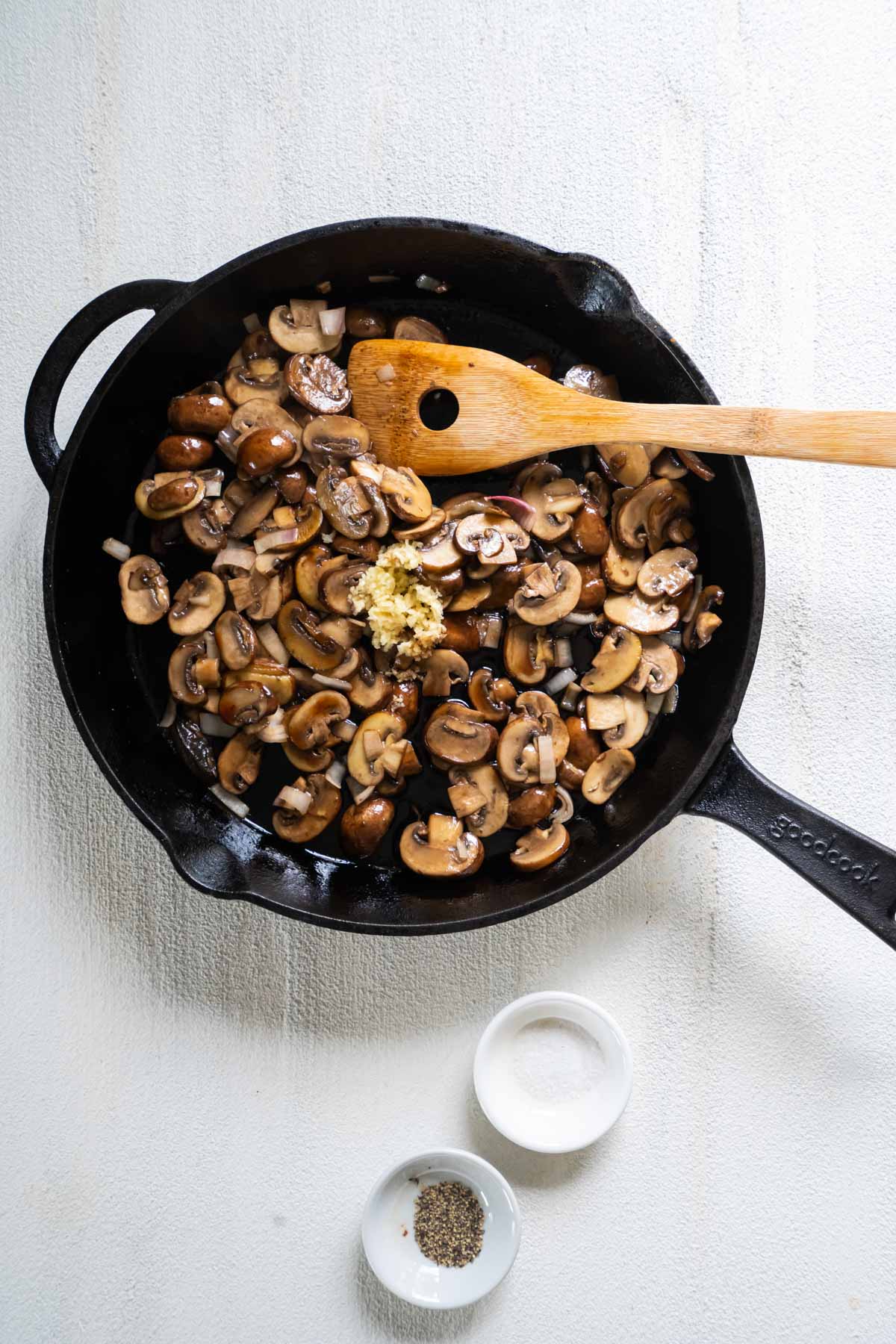 Minced garlic added to pan with sauteed mushrooms.