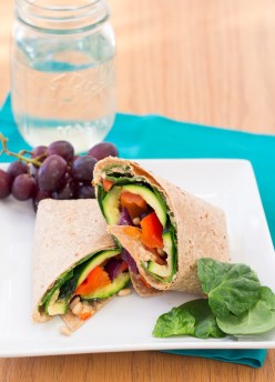 Hummus veggie wrap served with grapes.