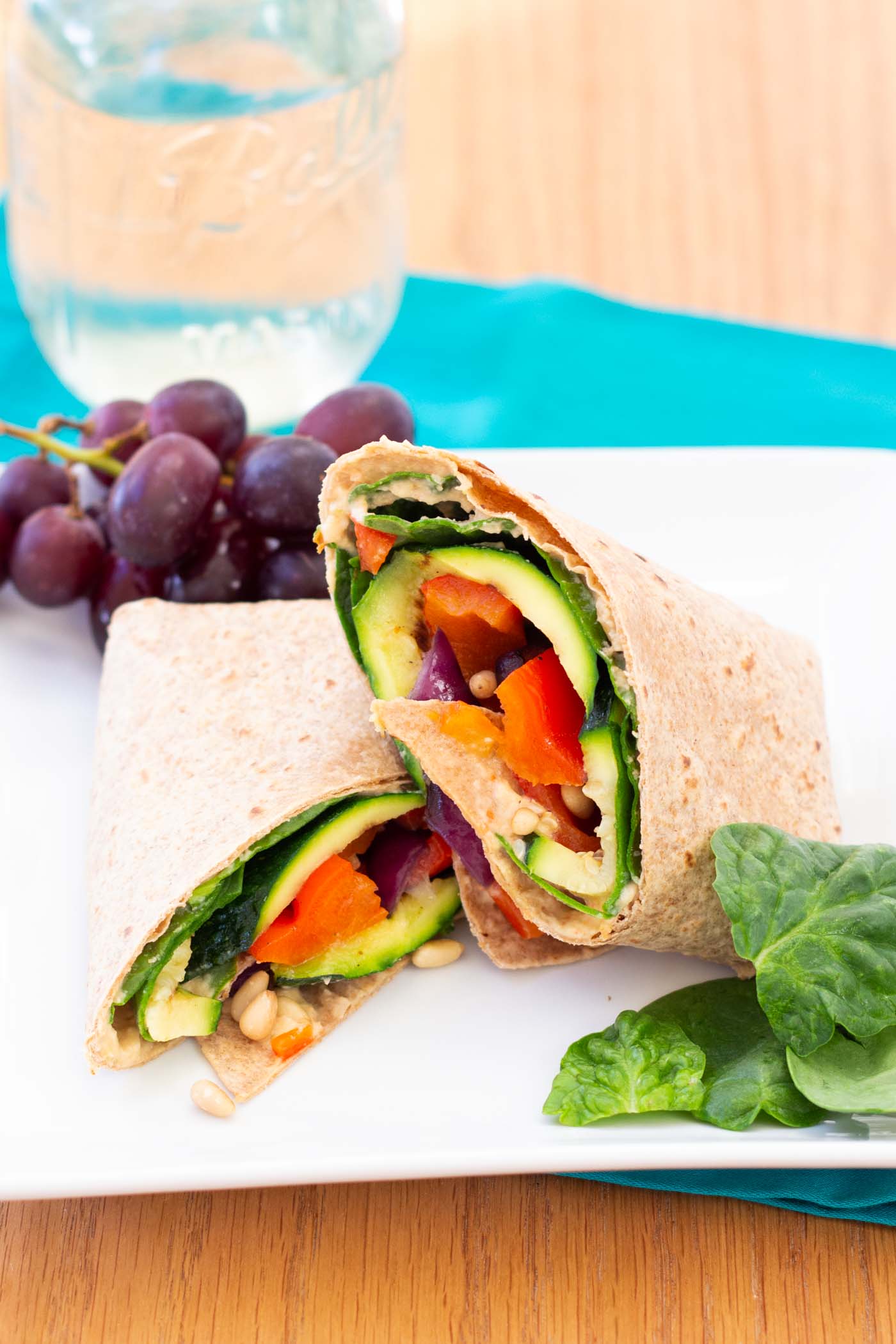 Grilled vegetable hummus wrap served with grapes.
