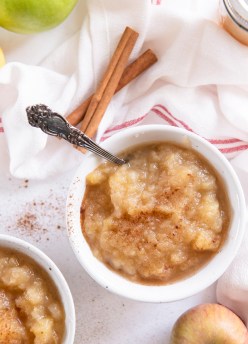 instant pot applesauce with cinnamon in a small white bowl with a spoon