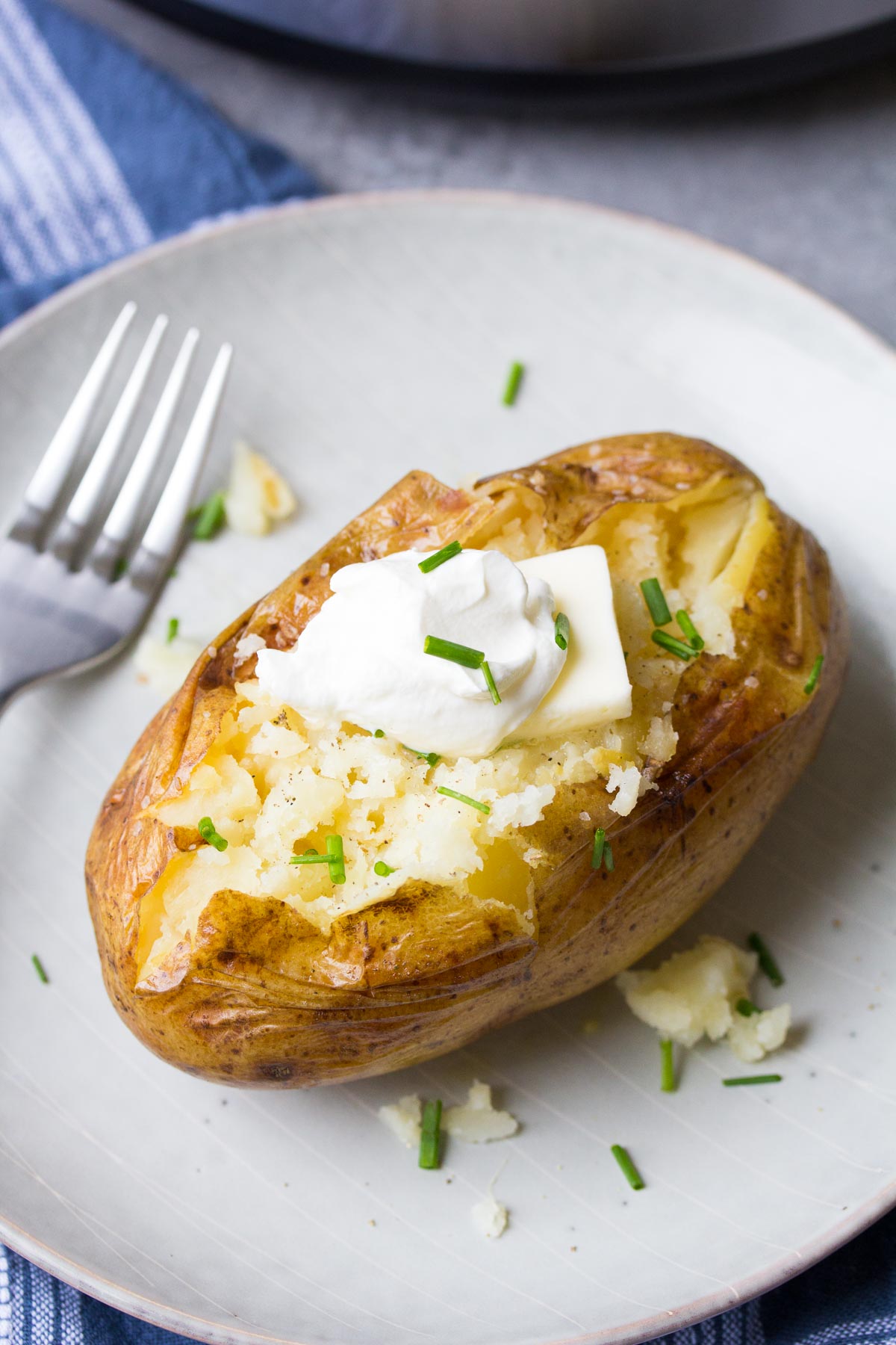 Instant pot baked potato topped with sour cream and chives.