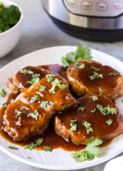 pork chops with honey garlic sauce on a plate with instant pot in background