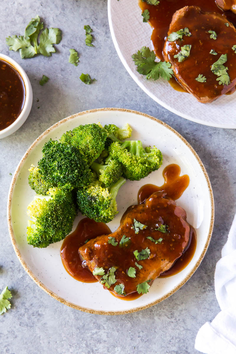 Honey garlic pork chop on a plate with broccoli.