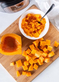 quartered, cubed and mashed butternut squash with instant pot in background