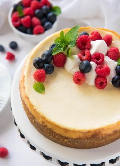 Instant pot cheesecake topped with whipped cream and berries.