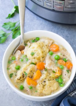 Instant Pot Chicken and Dumplings in a white bowl with a spoon.
