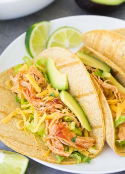 Close up of Instant Pot chicken tacos, with salsa chicken, lettuce, cheese and avocado.