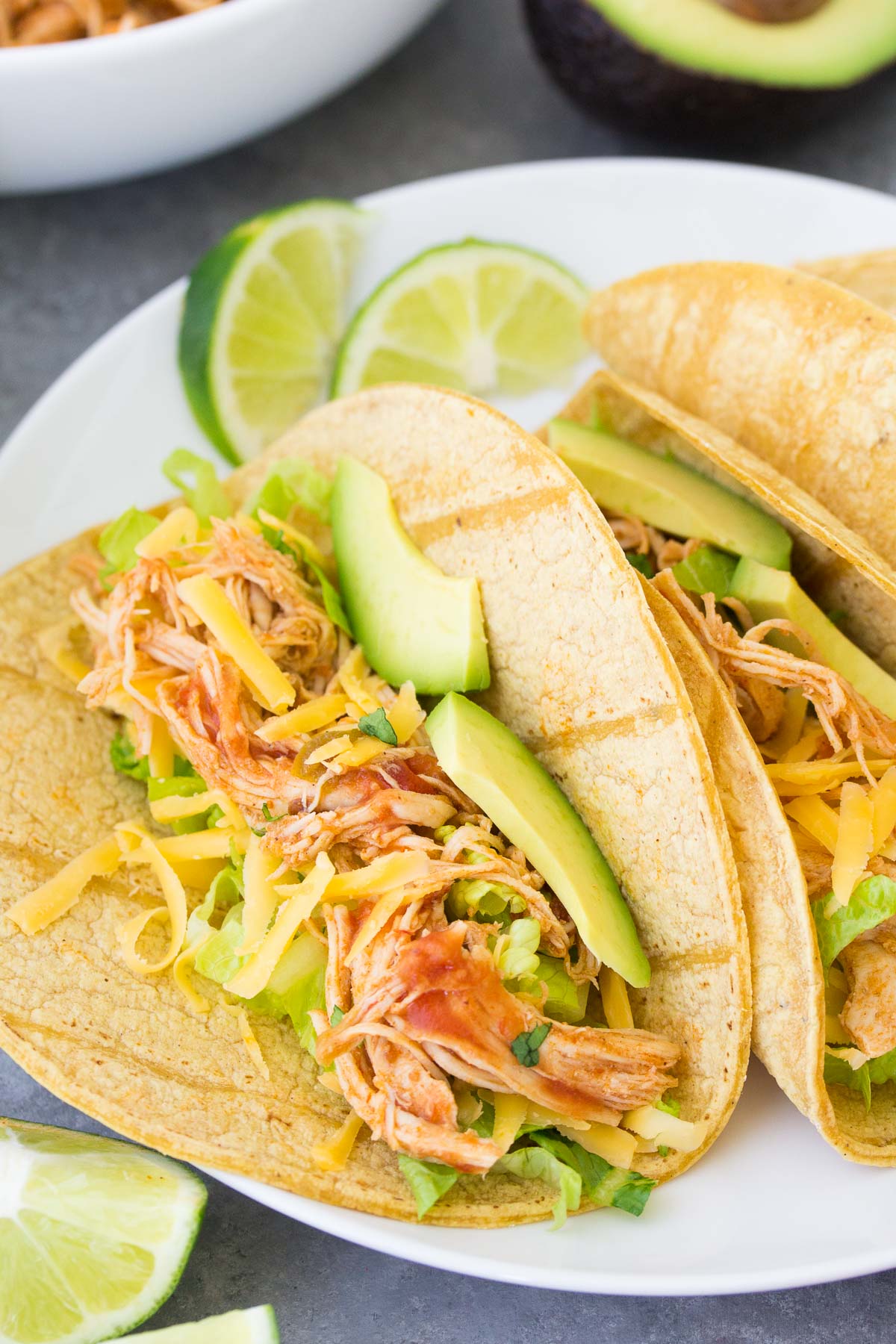 Close up of Instant Pot chicken tacos, with salsa chicken, lettuce, cheese and avocado.