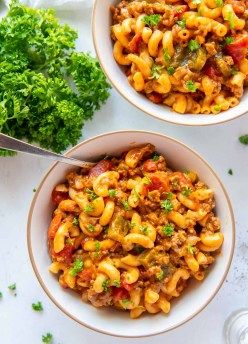 instant pot goulash in two serving bowls with fresh parsley