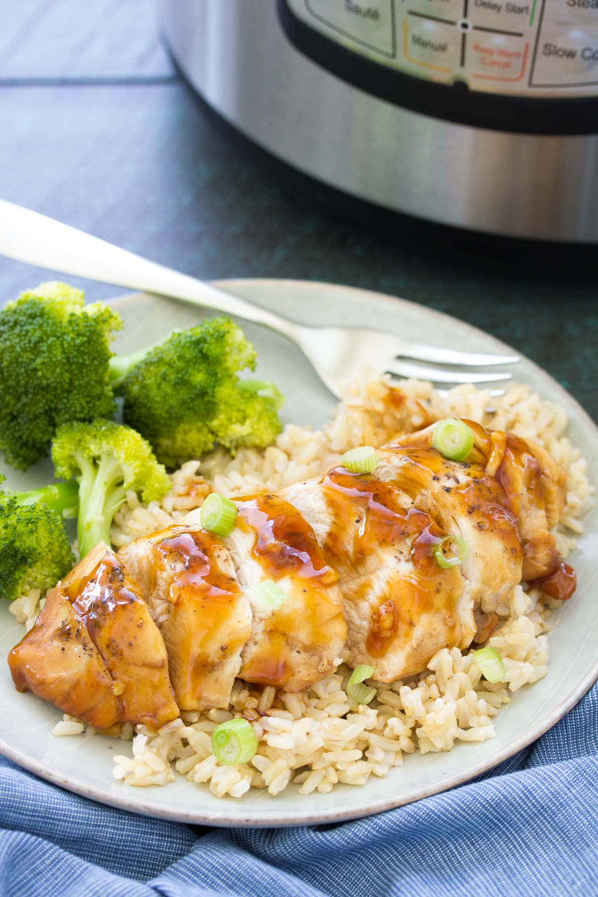 Instant pot honey garlic chicken breast served with rice and broccoli.