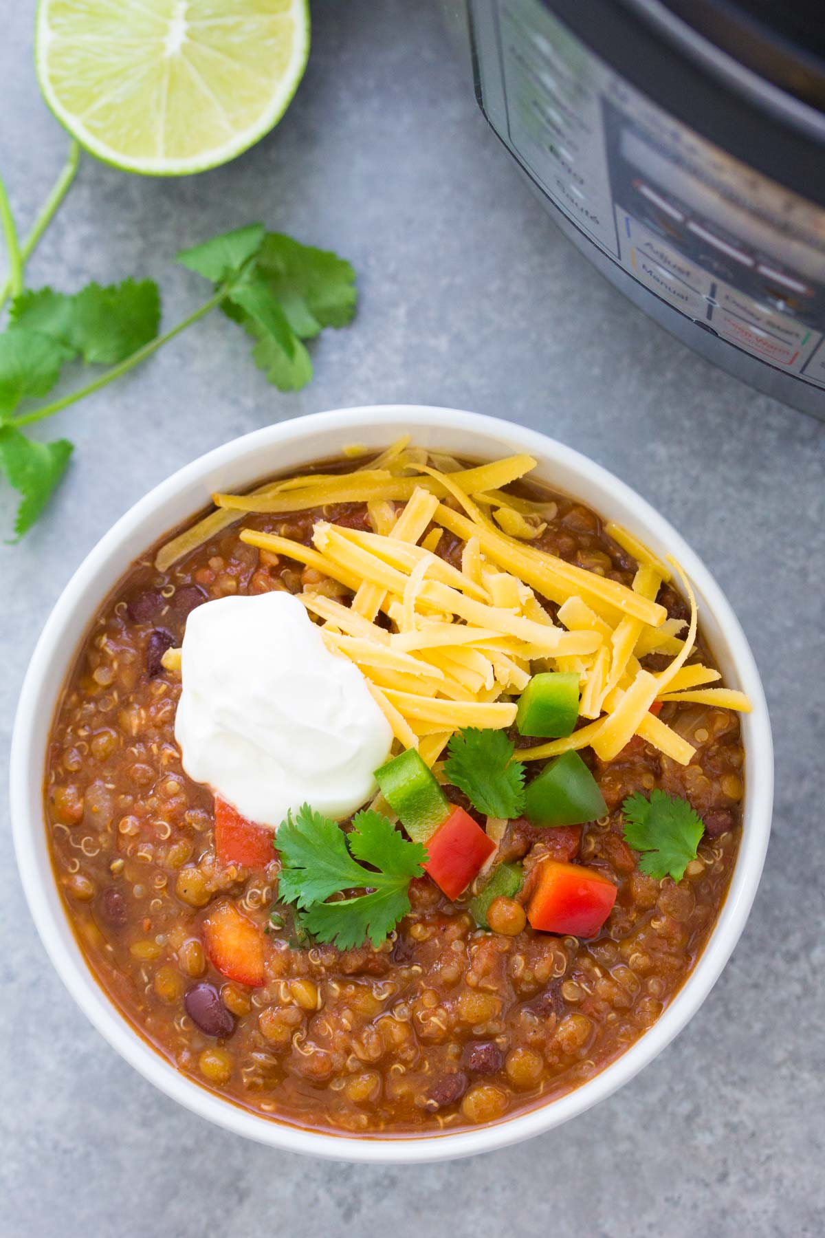 Instant pot lentil chili served in a white bowl with toppings.