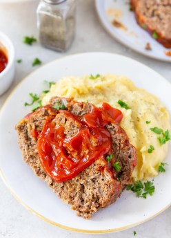 Two slices of instant pot meatloaf served with meatloaf sauce and mashed potatoes.