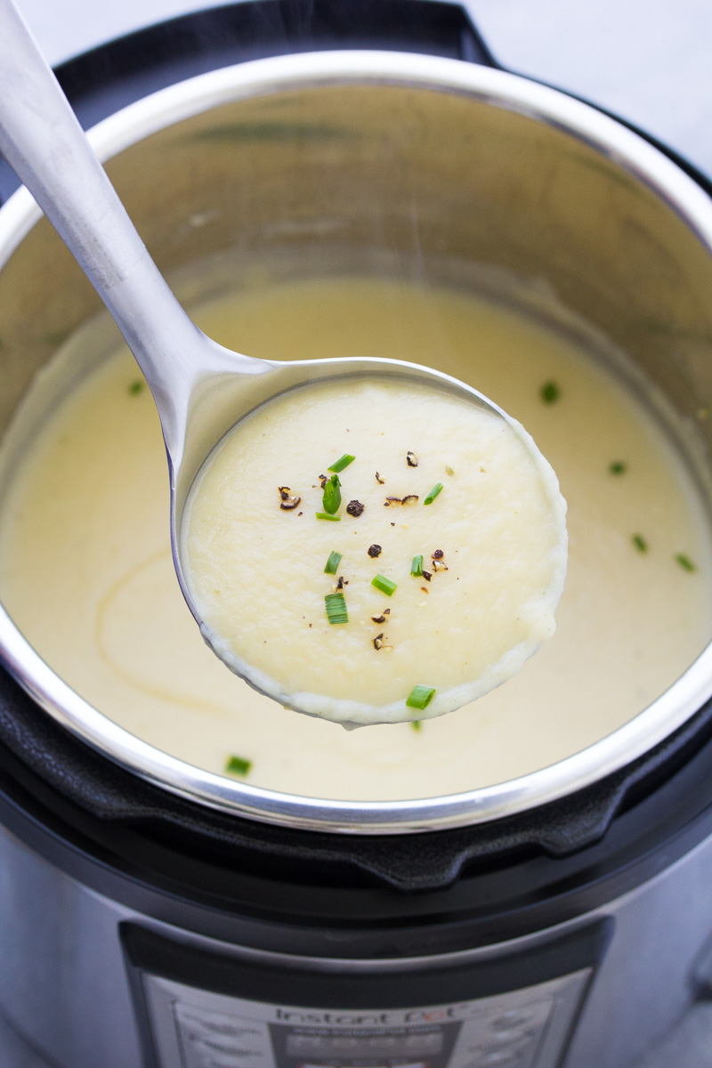 Leek and potato soup on a ladle over an instant pot.