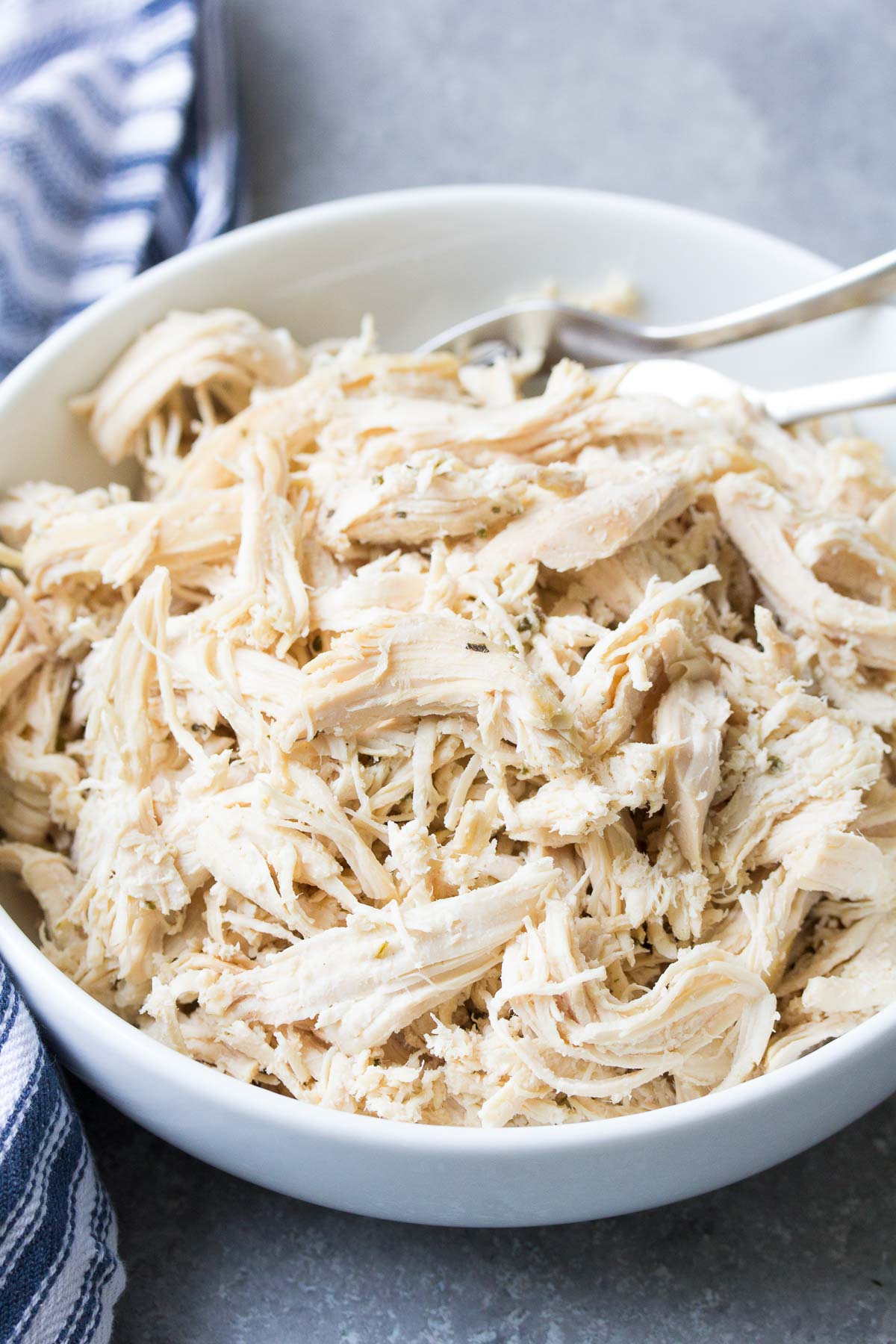 Instant pot shredded chicken in a white bowl.