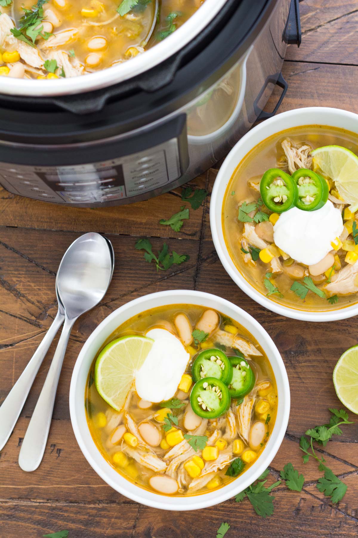 Two bowls of instant pot white chicken chili with instant pot in background.