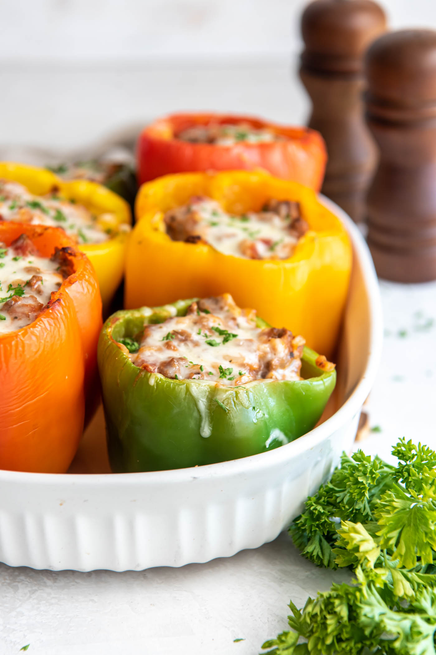 Side view of stuffed peppers in baking dish.
