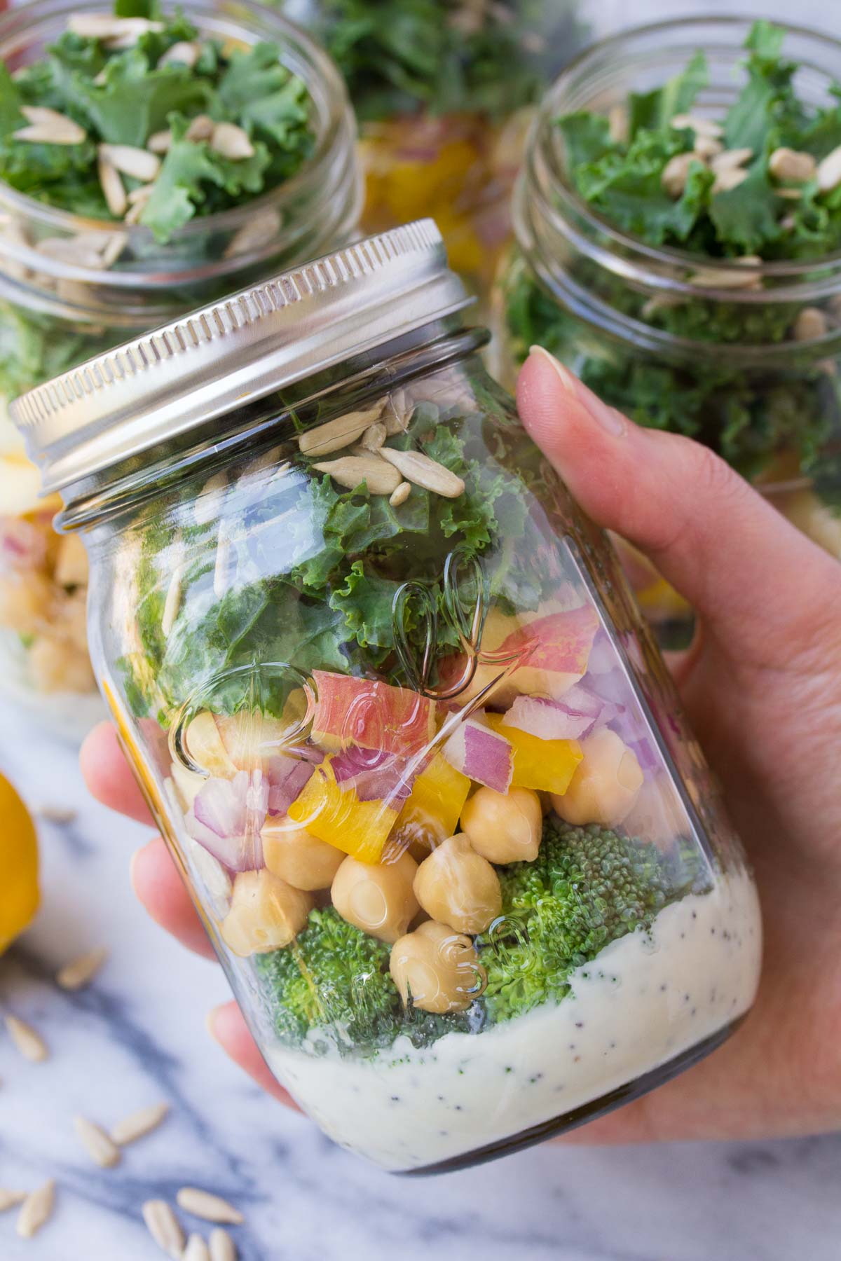 Layered broccoli salad with chickpeas in a mason jar.