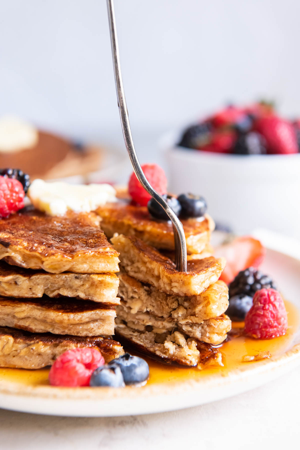 Stack of oatmeal pancakes with bite on a fork.