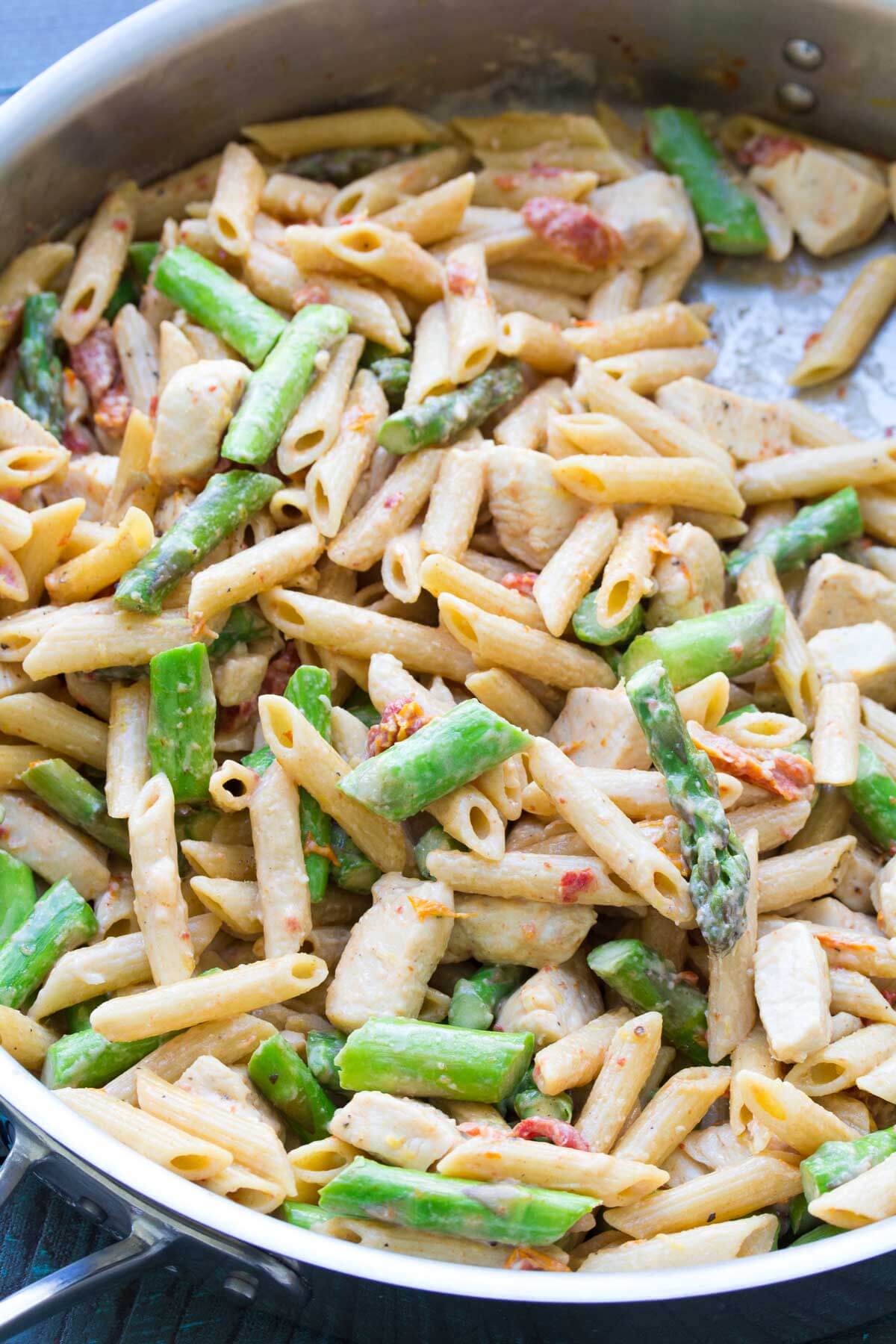 Chicken and asparagus pasta in a skillet.