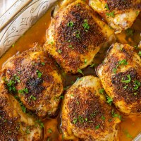 Oven baked chicken thighs in baking dish.