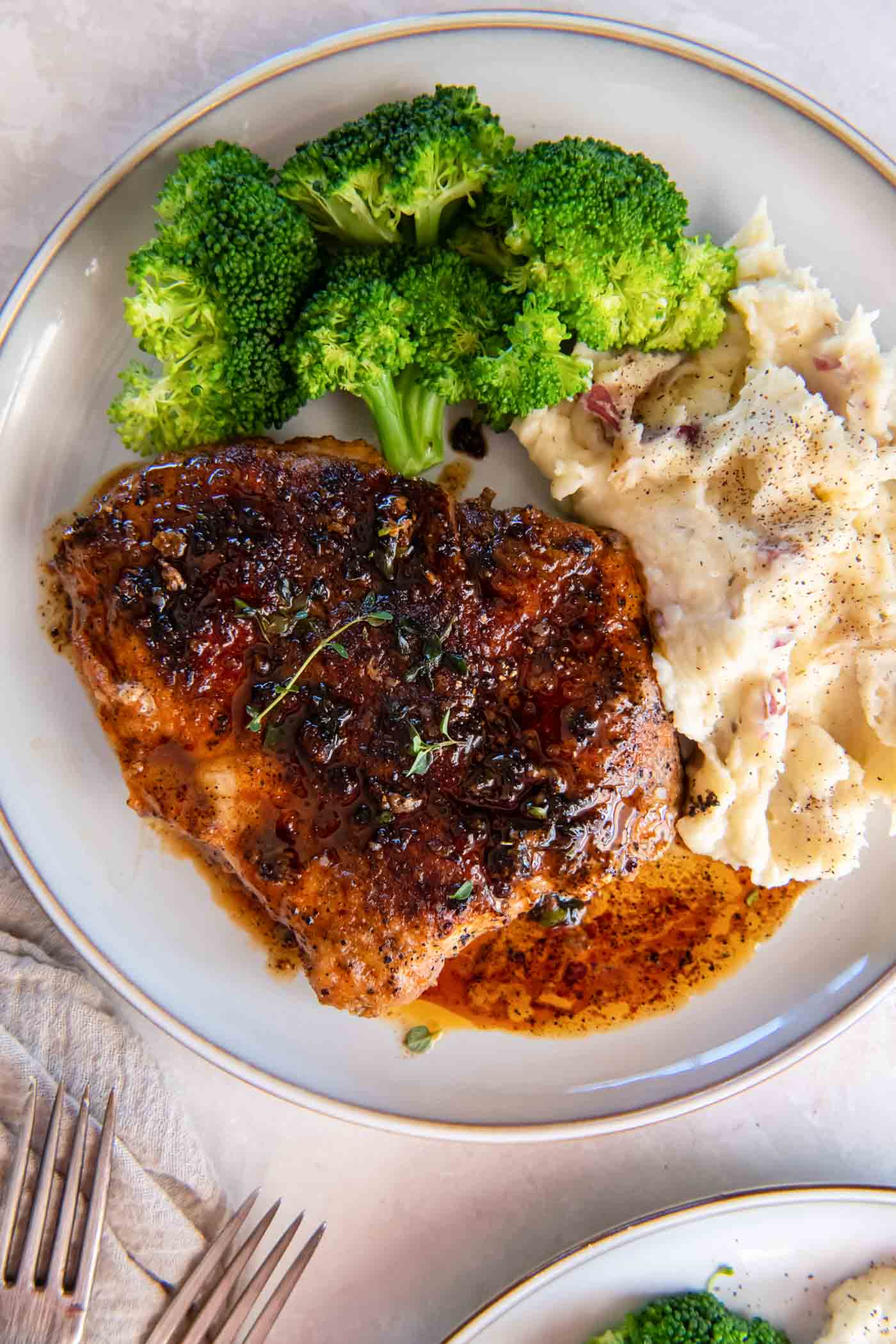 Pan fried pork chop served with mashed potatoes and broccoli.