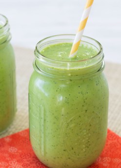 Kale smoothie in a glass with a straw.