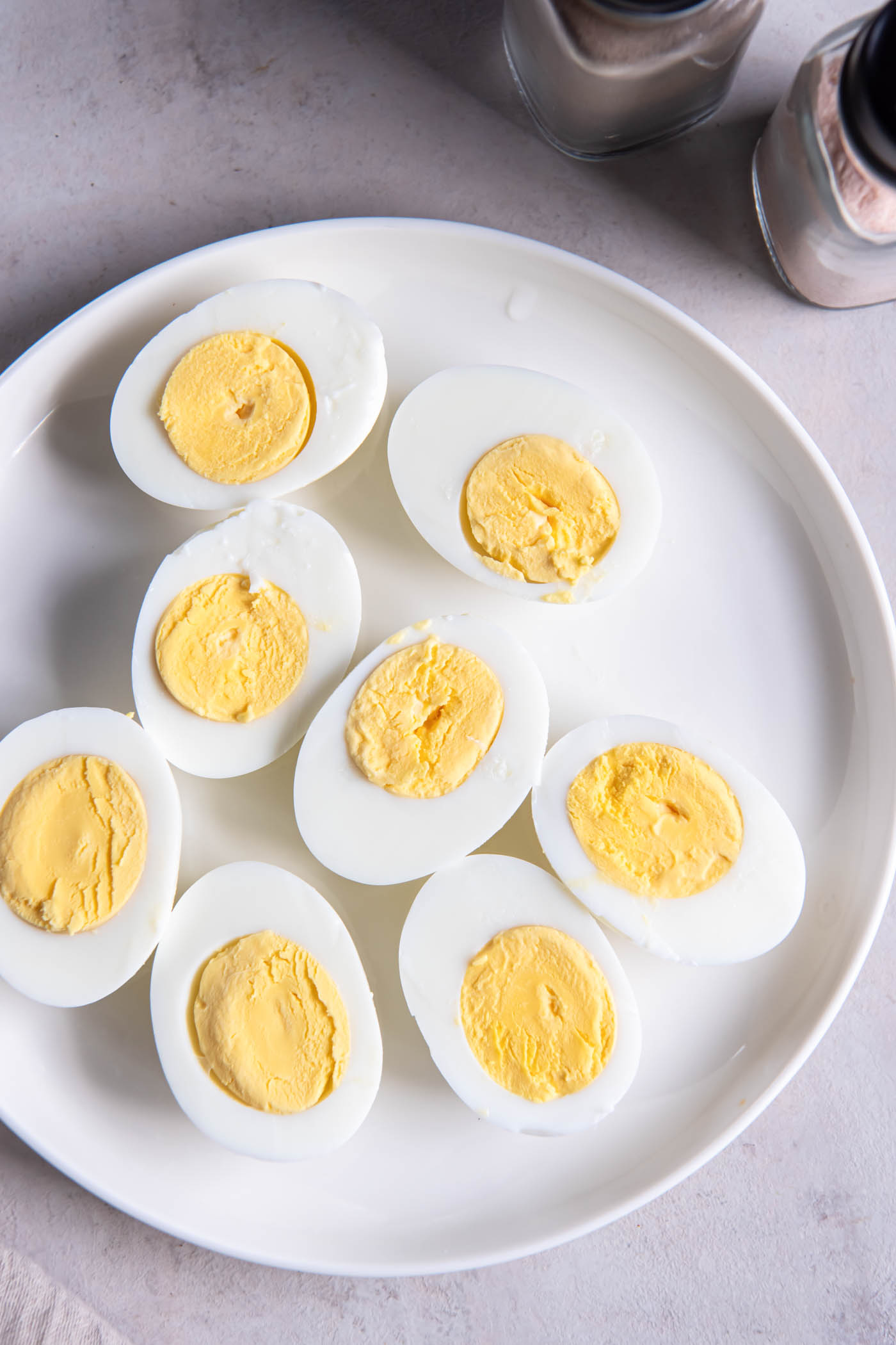 Hard boiled eggs cut in half on a plate.