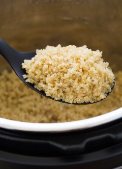 fluffy quinoa on a serving spoon held over an instant pot