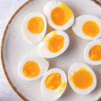 Eight soft boiled egg halves on a plate.