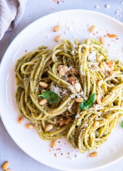 Pesto pasta with pine nuts, parmesan and basil served on a plate.