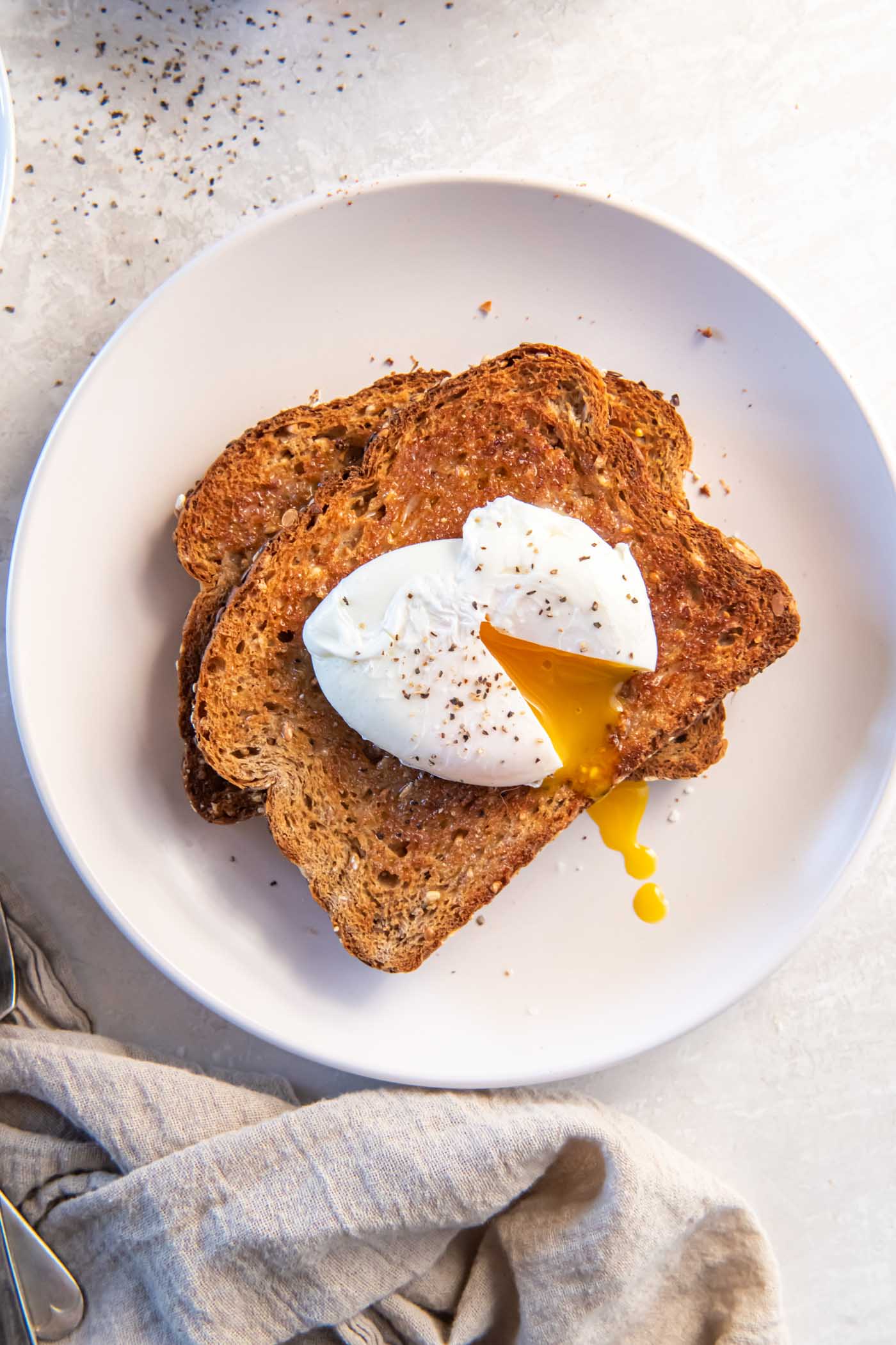 Poached egg served on buttered whole wheat toast.