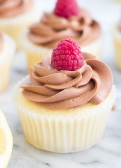 lemon cupcakes with chocolate frosting and a fresh raspberry on top