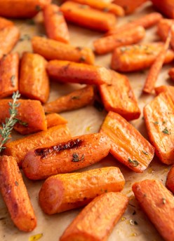 Roasted carrots with thyme on a baking sheet.