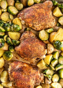 Roasted chicken thighs, potatoes and Brussels sprouts on sheet pan.