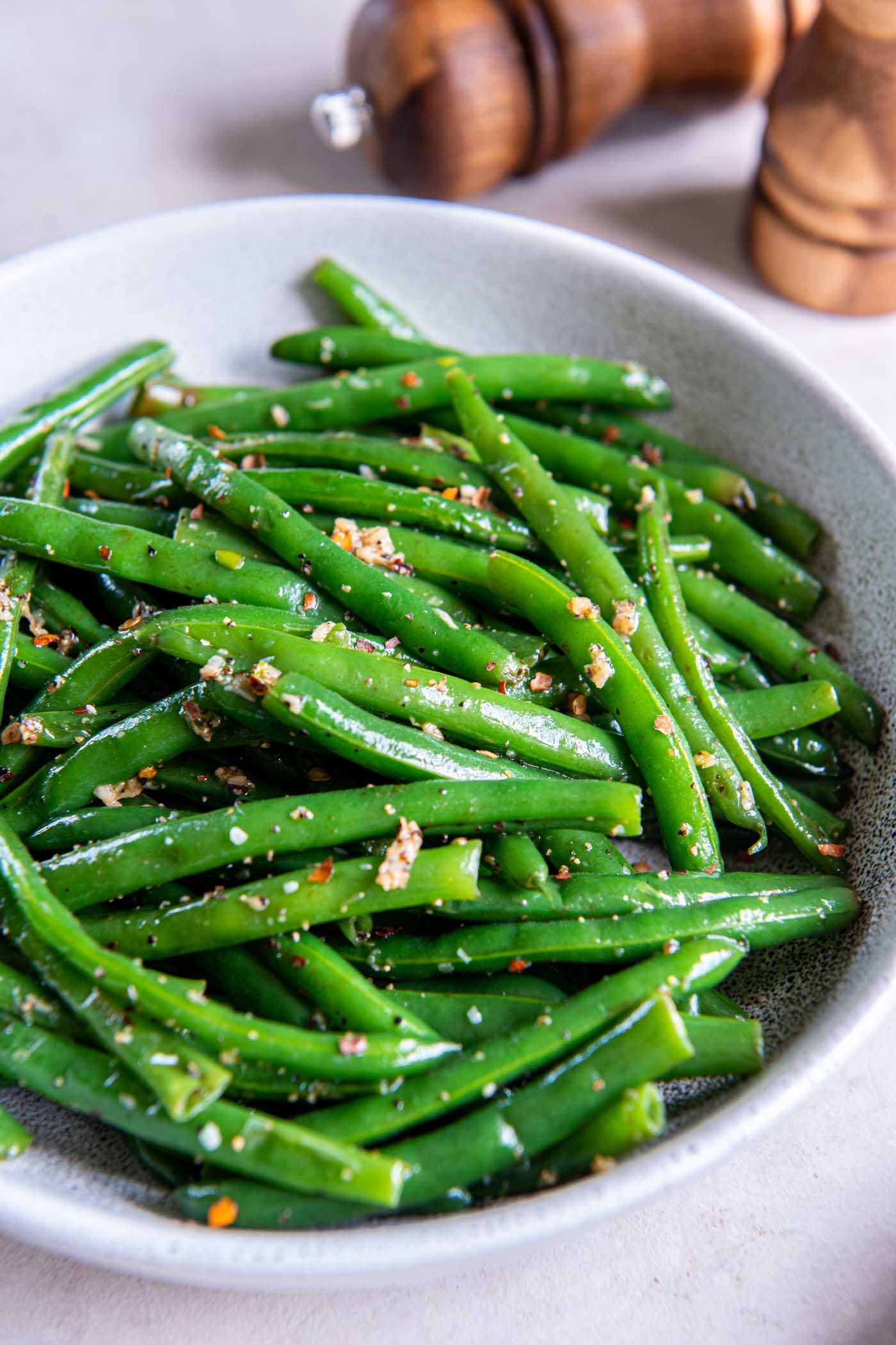 Sauteed green beans with garlic and red pepper flakes in a serving bowl.
