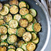 Sauteed zucchini with parmesan in skillet.