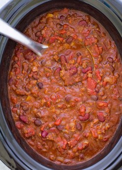 Chili in a slow cooker with a ladle.