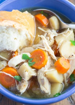 chicken stew in blue bowl with bread