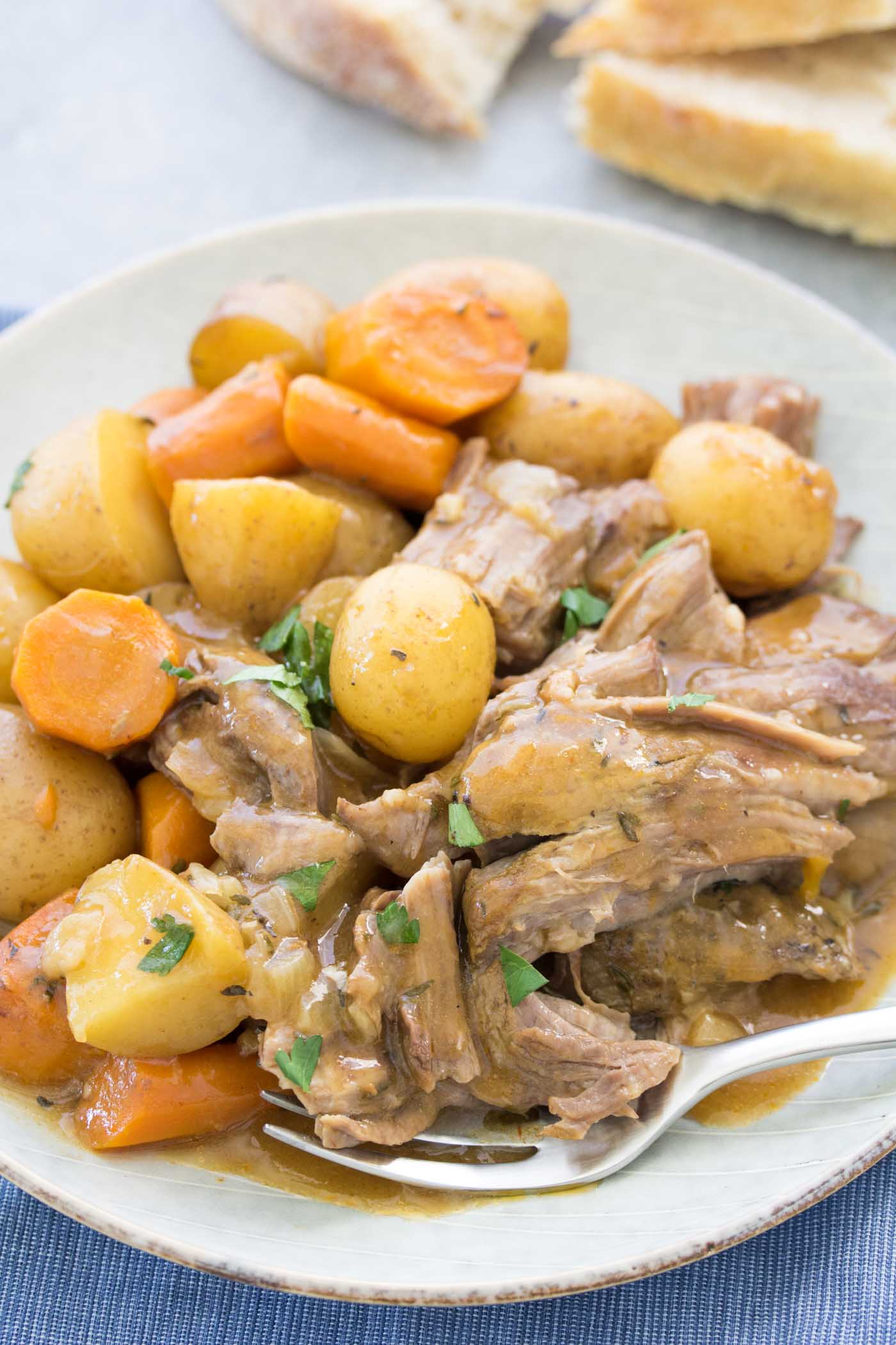 Pot roast with potatoes and carrots served on a plate with a fork.