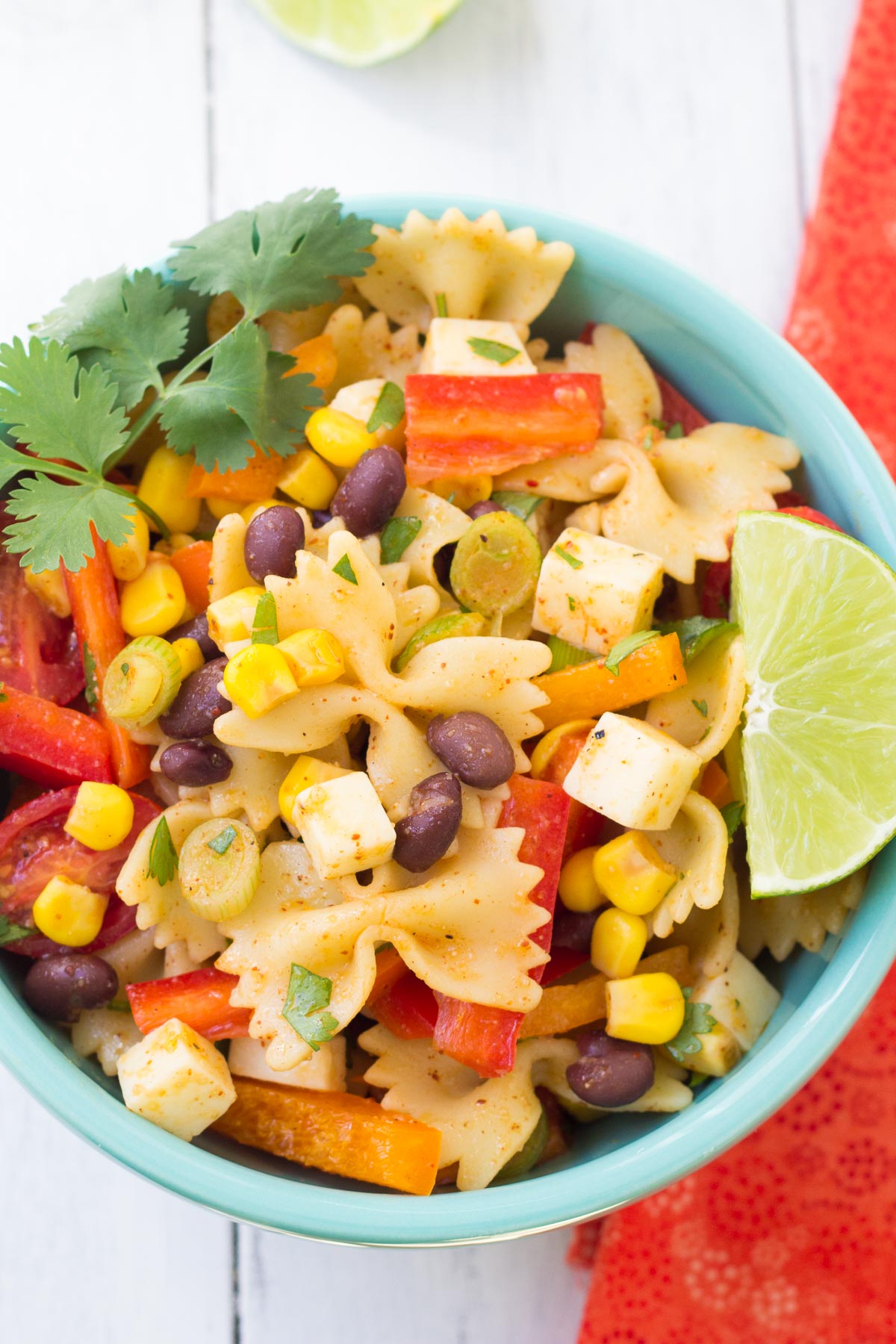 Southwestern pasta salad in a bowl with a lime wedge.