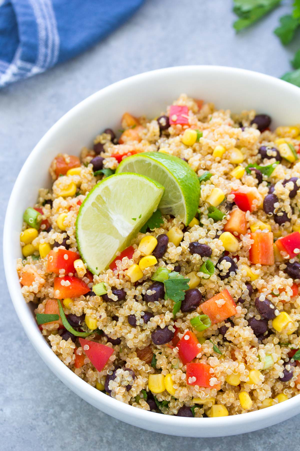 Southwest quinoa salad in a serving bowl with lime wedges.