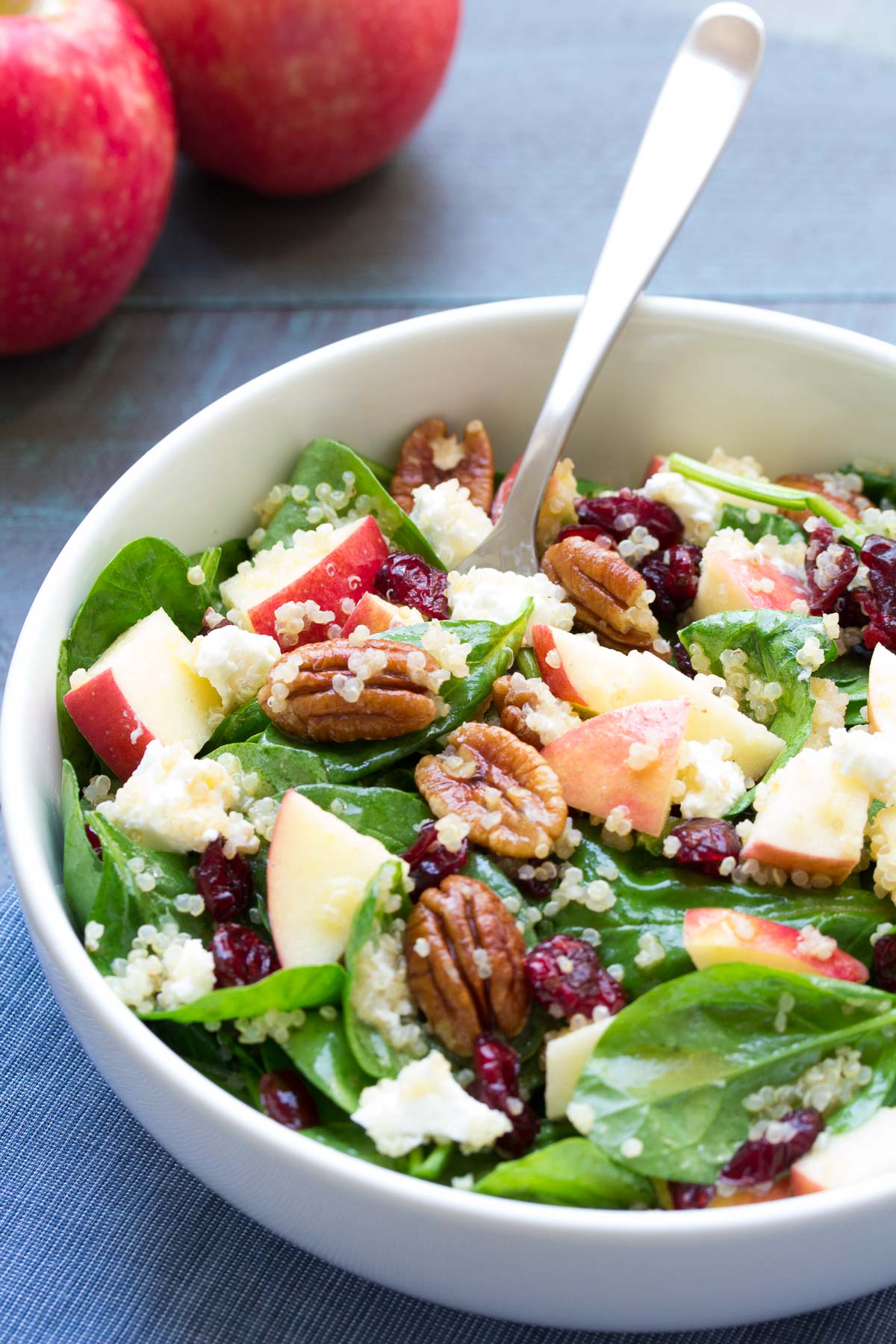 Spinach and Quinoa Salad with Apple and Pecans served in a bowl with a fork.