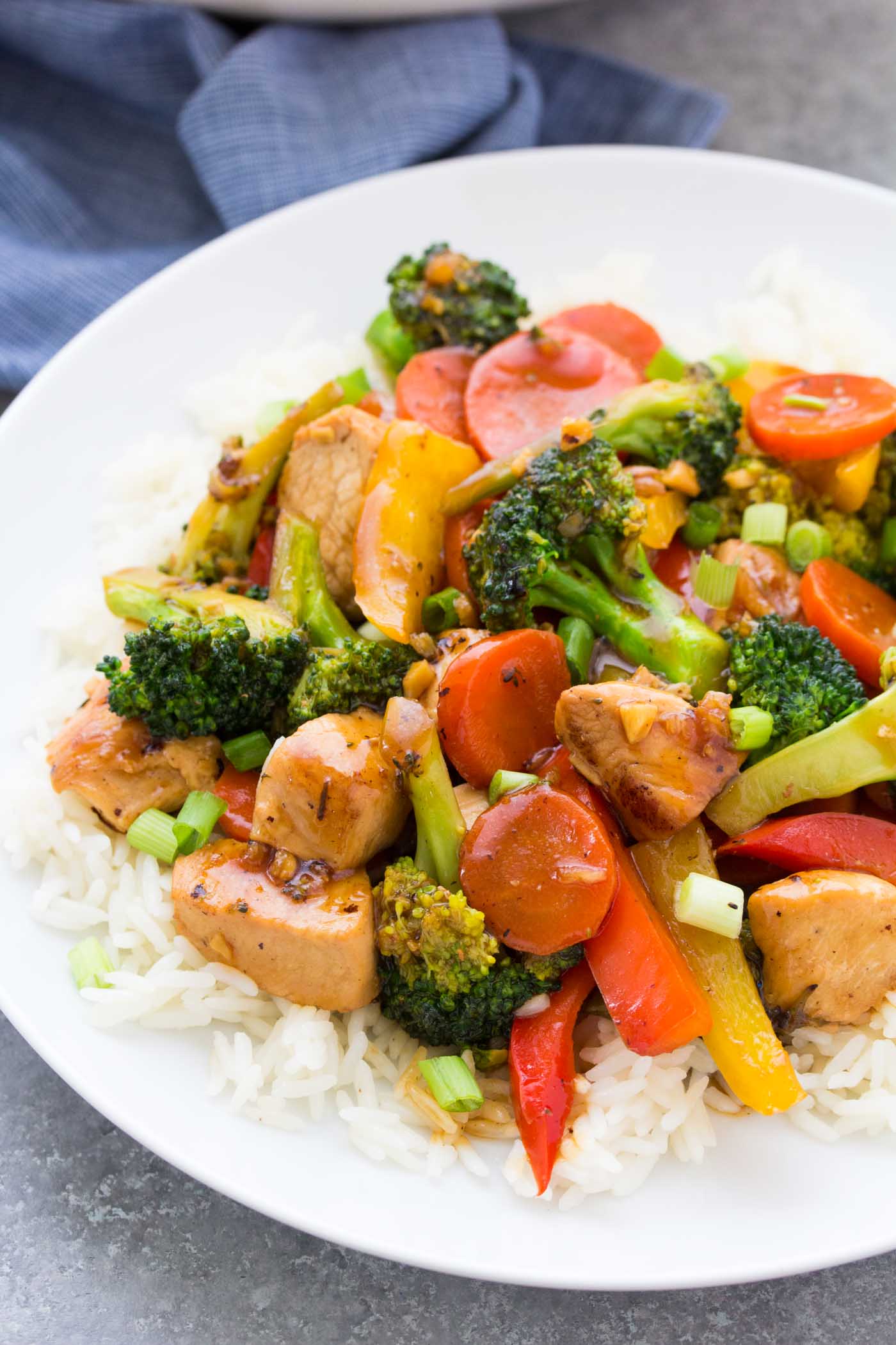 Chicken stir fry with vegetables served over rice.
