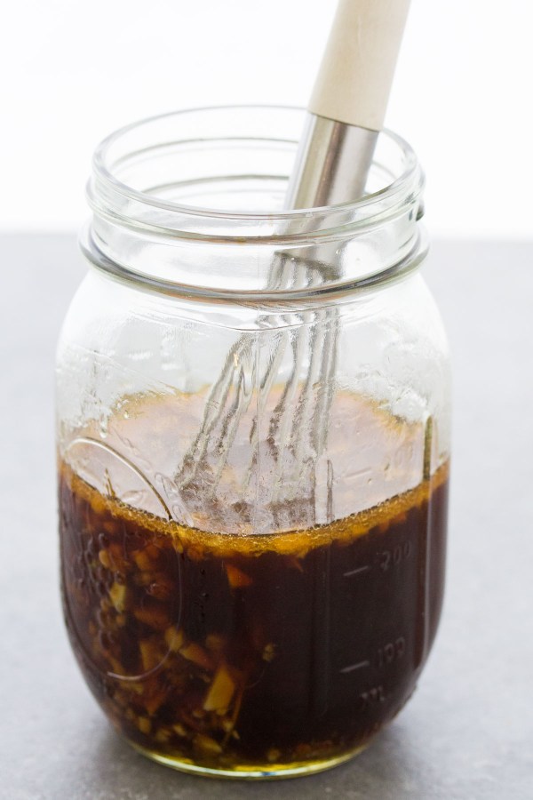 Stir fry sauce with ginger and garlic in a jar with a whisk.