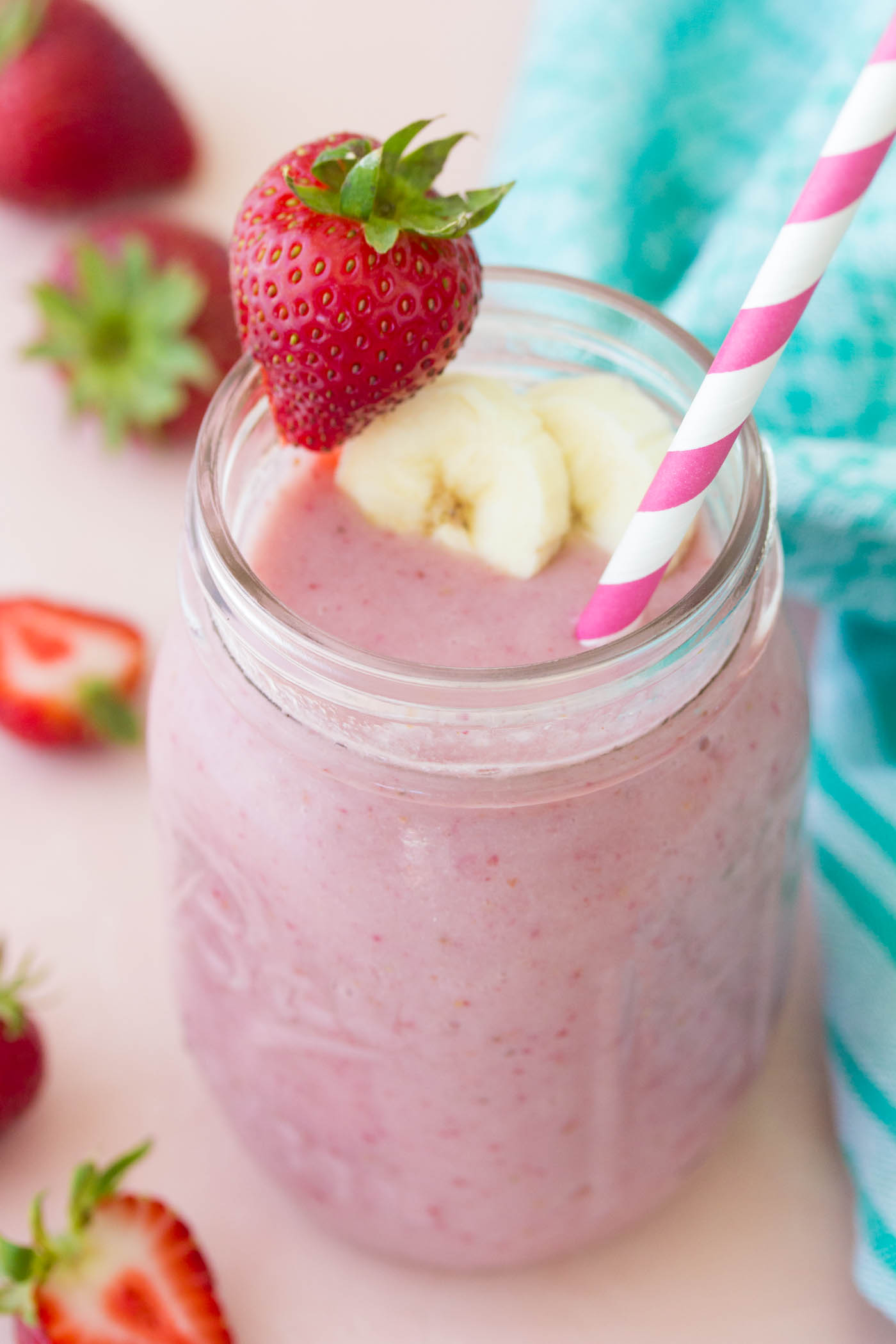 Strawberry banana smoothie in a mason jar with a straw.