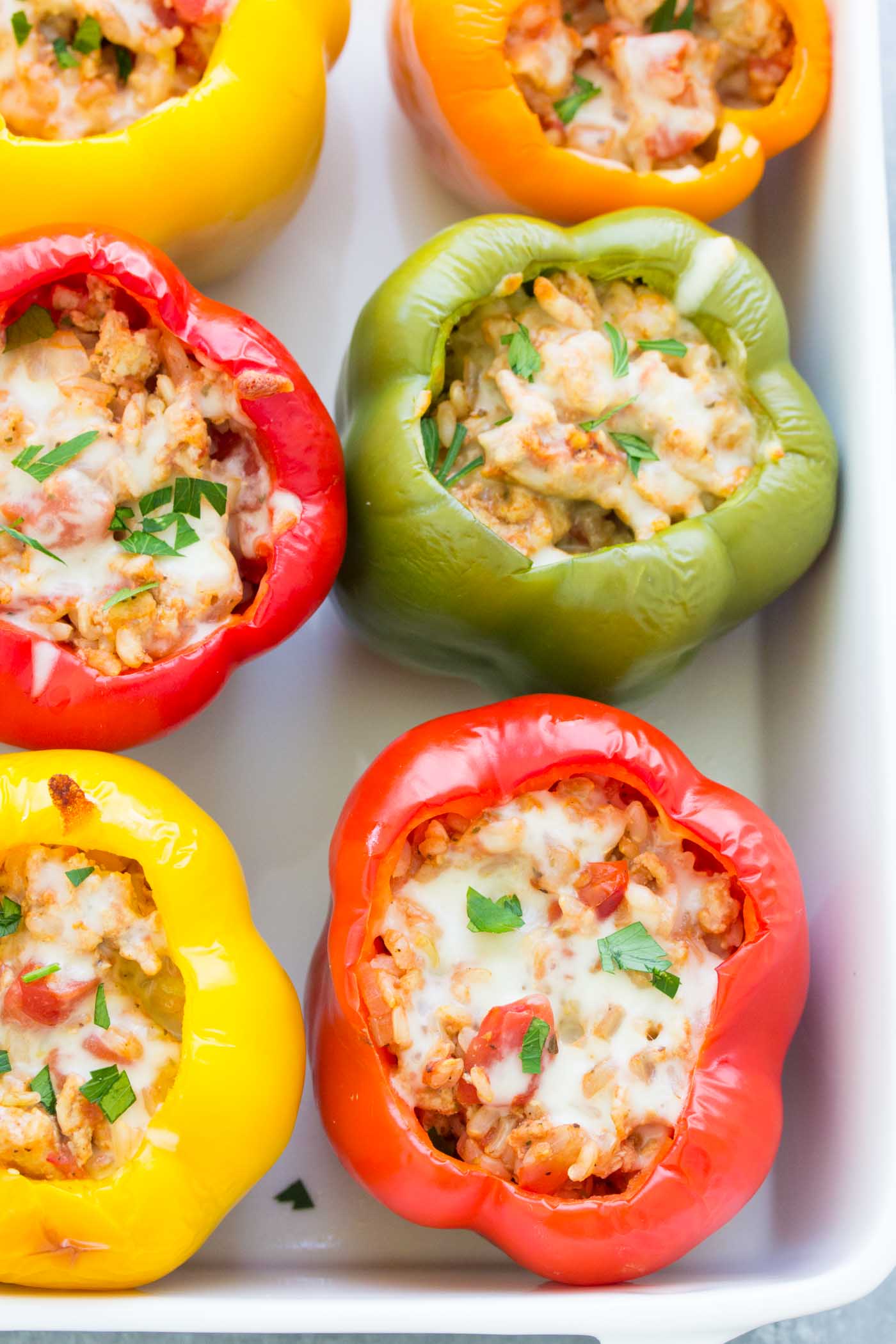 Stuffed bell peppers made with ground turkey in a baking dish.
